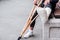 Unrecognizable girl sits on the street on a bench with a broken leg and crutches.disabled girl with crutches.an accident