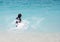 Unrecognizable girl splashing in crystal clear blue sea water.