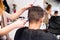 Unrecognizable hairdresser shaving head of her young client.