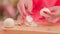 Unrecognizable lady peeling boiled egg on wooden board outdoors. Woman's hands with bright manicure peeling chicken