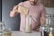 Unrecognizable latin man filling up a jar with basmati rice from a paper bag.