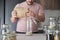 Unrecognizable latin man filling up a jar with round grain rice from paper bag.