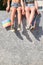 Unrecognizable lesbian couple sitting, hands holding rainbow flags.