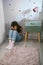 Unrecognizable little girl covering her face with hands sitting on the floor