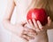 Unrecognizable little girl holding a red apple