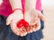 Unrecognizable little girl holding a red heart