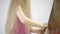 Unrecognizable little girl in pink combing her friends long blonde hair
