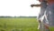 Unrecognizable little sisters swinging on a rope swing in a field. No faces.