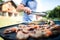 Unrecognizable man cooking seafood on a barbecue grill in the backyard.