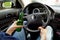 Unrecognizable man drinking and driving. Dangerous driving conce