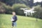 Unrecognizable man with flying drone. Sunny green nature.