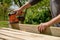 Unrecognizable man in the garden sanding wooden planks. DIY home improvement, restoration, carpentry concept.