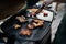 Unrecognizable man grilling meat and vegetable on grill during family summer garden party, close-up