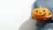 An unrecognizable man holds a carved Halloween pumpkin in front of him. Crop portrait Man in a blue sweater with an