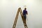 Unrecognizable man on ladder back view paints white wal