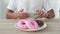 Unrecognizable man photographs donuts on a smartphone