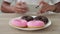 Unrecognizable man photographs donuts on a smartphone.