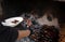 Unrecognizable man picking up the meat from a firewood barbecue with coals in the background. Close up.