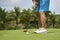 Unrecognizable man playing golf putting on green