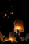 Unrecognizable man releasing paper lantern during Loi Krathong and Yi Peng festival in Chian Mai