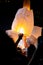 Unrecognizable man releasing paper lantern during Loi Krathong and Yi Peng festival in Chian Mai