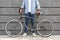 Unrecognizable Man Standing With Stylish Bicycle Over Grey Urban Wall