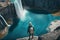 Unrecognizable man tourist with backpack looking at wonderful waterfall
