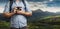 Unrecognizable Man Traveler Blogger Man With Backpack And Film Camera Near Mountains. Hiking Tourism Journey Concept