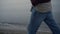 Unrecognizable man walking sea beach. Guy holding hands in jeans pockets closeup