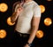 An unrecognizable man in a white T-shirt with a shirt stands in a dark room