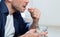 Unrecognizable Mature Man Taking Medicine Pill Sitting At Home, Cropped