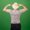 Unrecognizable middle-aged man wearing a hat against a green background demonstrates strength and confidence. Back view. Place for