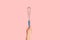 Unrecognizable millennial girl holding kitchen whisk over pink background, closeup
