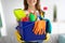 Unrecognizable millennial maid holding bucket with cleaning supplies indoors, closeup of hands. Sanitary service concept