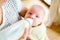 Unrecognizable mother feeding baby son, milk in bottle, close up