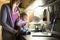 Unrecognizable mother with son in the arms, laptop on kitchen co