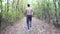 Unrecognizable muscular sportsman running along trail at early autumn forest. Young athlete sprinting along path at