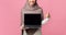 Unrecognizable muslim woman holding and pointing at laptop with black screen