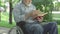 Unrecognizable paralyzed senior man turning book page and reading out loud. Old grey-haired male Caucasian retiree