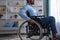 Unrecognizable paraplegic black guy in wheelchair suffering from depression at home, closeup