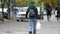 Unrecognizable passers-by are walking down the street. Defocused image. Lady