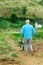 Unrecognizable person from the countryside in selective approach in his orchard with a wheelbarrow along a dirt road surrounded by