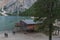 Unrecognizable photographers near house on the beach of Lake Braies at sunset