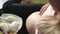 Unrecognizable pregnant eats cottage cheese and caresses tummy