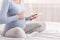 Unrecognizable Pregnant Woman Using Cellphone Sitting On Bed, Cropped