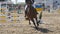 Unrecognizable professional male jockey rides on horseback. Horse is galloping and jumping through a barrier in