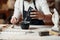 Unrecognizable professional stonemason with well-maintained hands making glue in special vessel for his handmade