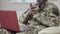 Unrecognizable relaxed military man messaging online using video chat on laptop. Positive African American soldier