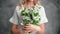 Unrecognizable romantic blonde woman posing with gentle white flowers bouquet isolated gray studio