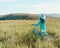 Unrecognizable romantic girl walking with bicycle in summer meadow.